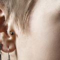 plusieurs piercings à l'oreille d'une jeune femme