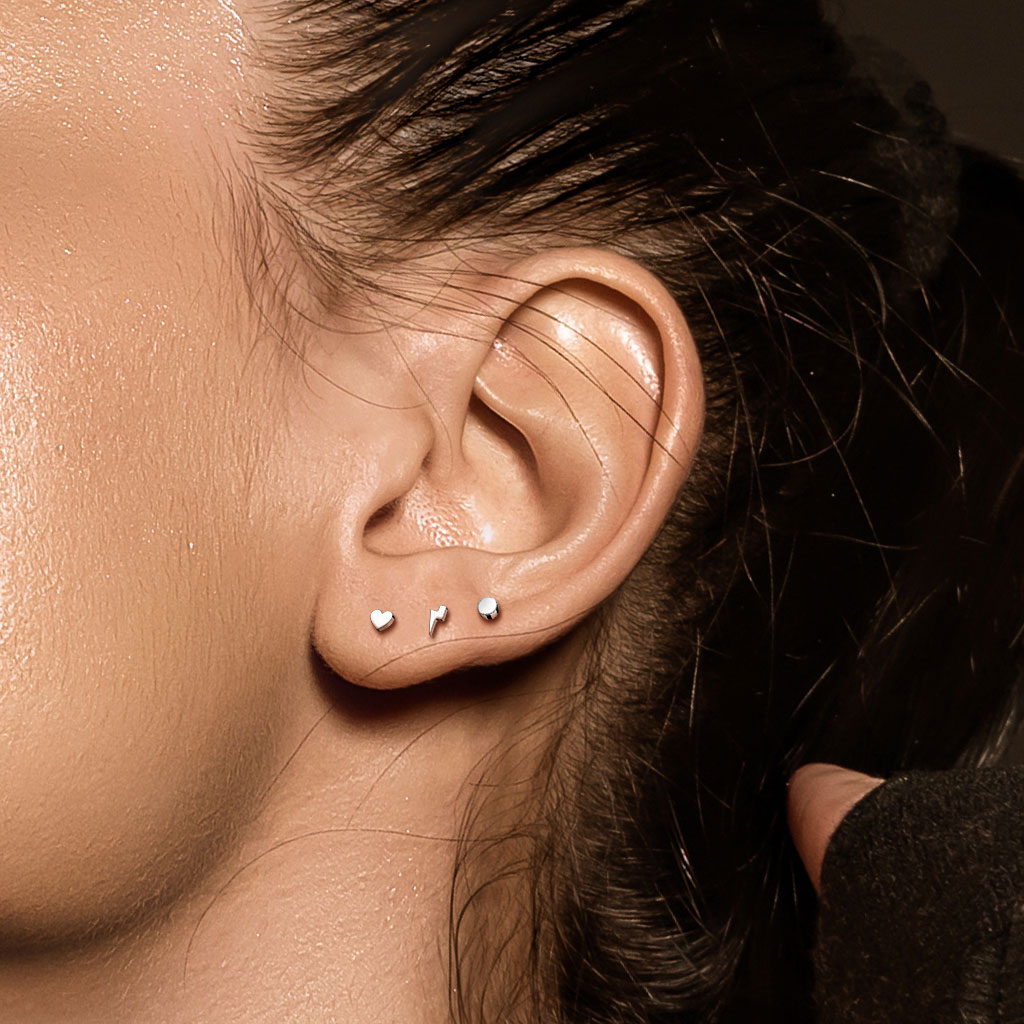 Vue d'une oreille avec des piercings hypoallergéniques en titane ASTM F136