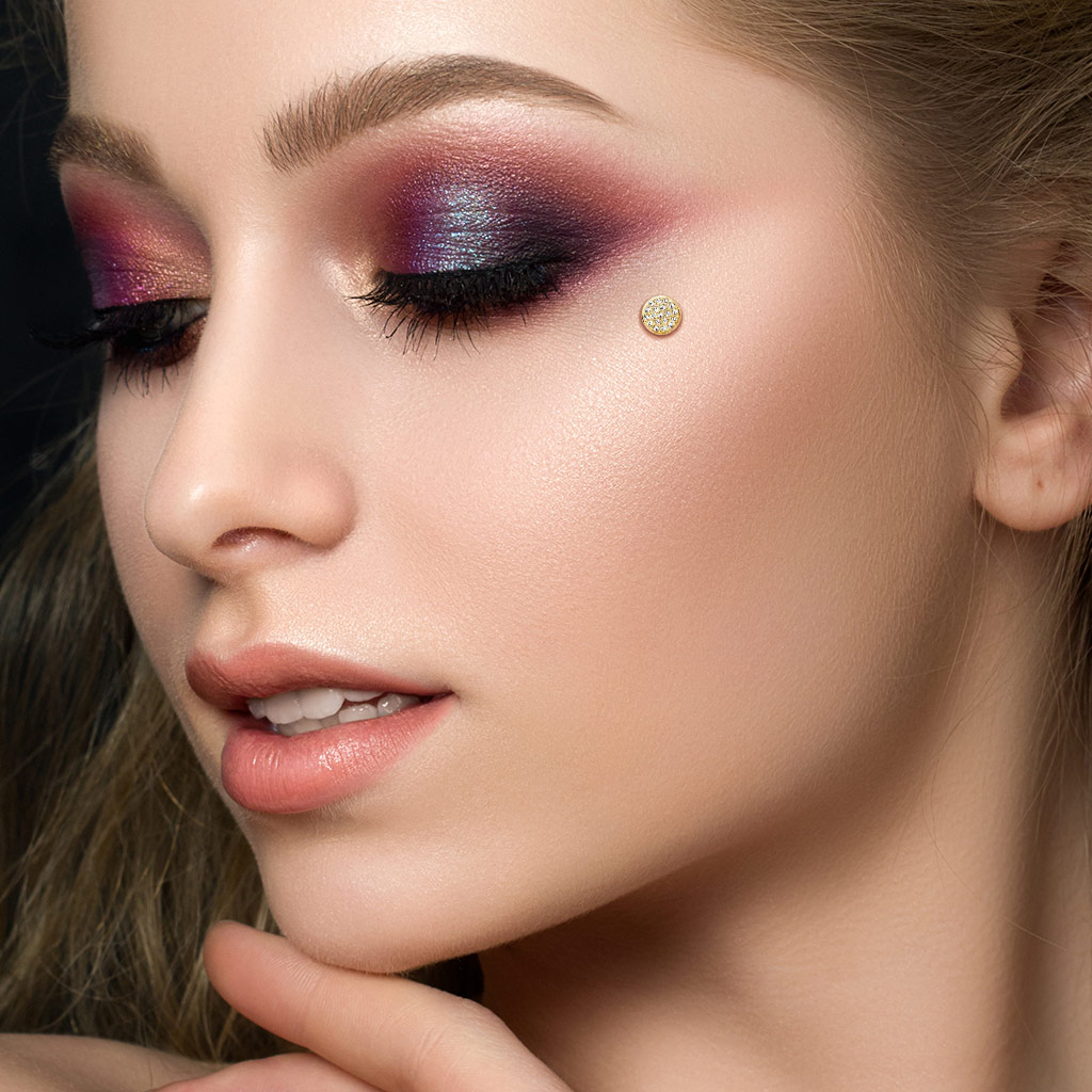 Piercing microdermal en or 14 carats positionné en haut de la joue