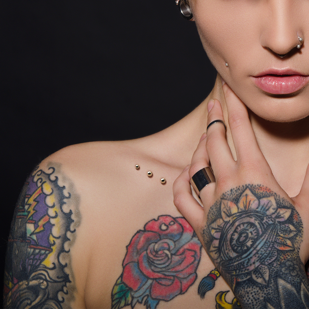 3 Piercings microdermal sur clavicule avec tatouages adjacents