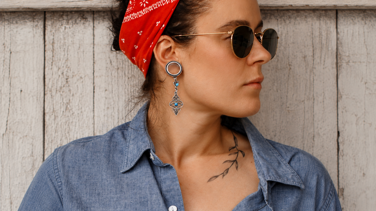 Portrait d'une jeune femme avec bandana rouge et plug turquoise au lobe d'oreille