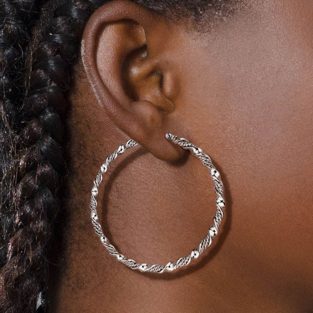 Jeune femme portant boucles d'oreilles créoles torsadées